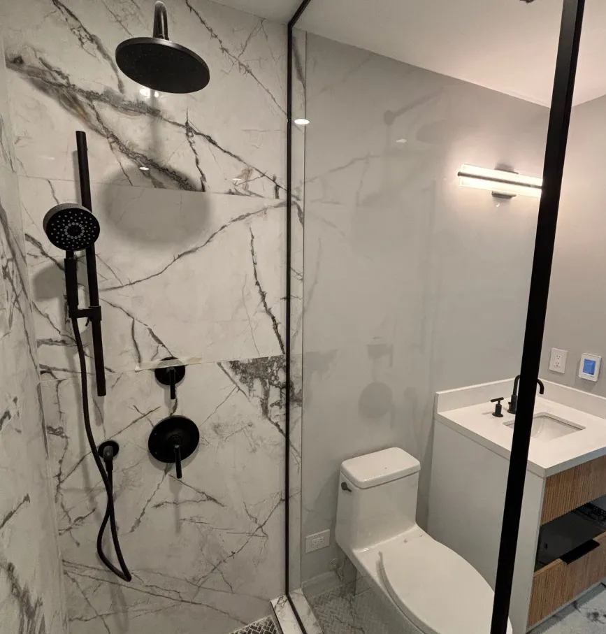 Bathroom with marble walls and matte black fixtures