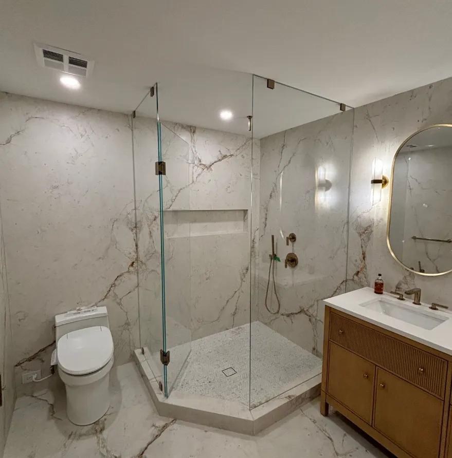 Walk-in marble shower with brass accents