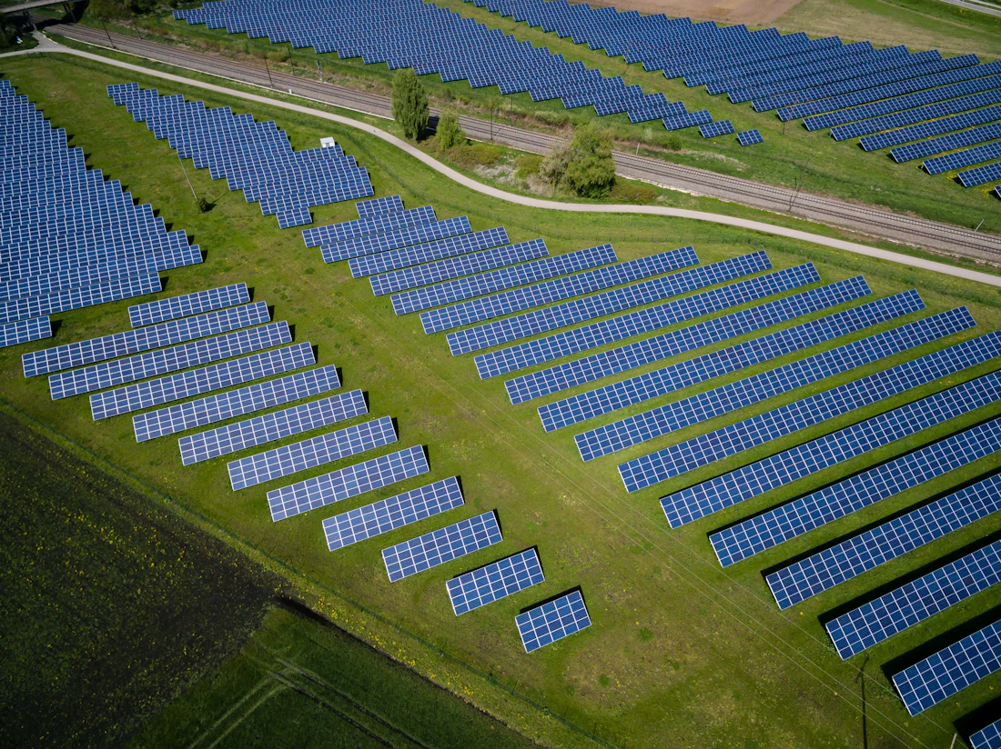 Aerial view of a solar panel array set in green farmland