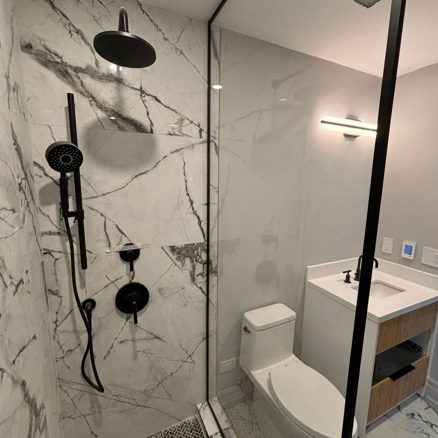 A finished bathroom renovation with tiled shower by Zeybek Construction in Ontario