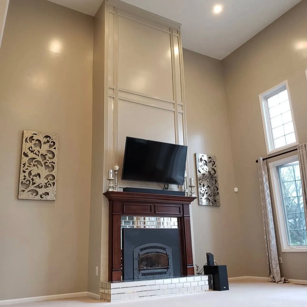A finished living room with a fireplace and tall windows in an Ontario home by Zeybek Construction